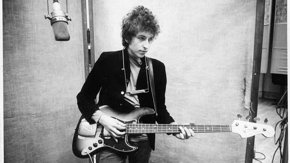 a young Bob Dylan playing the guitar
