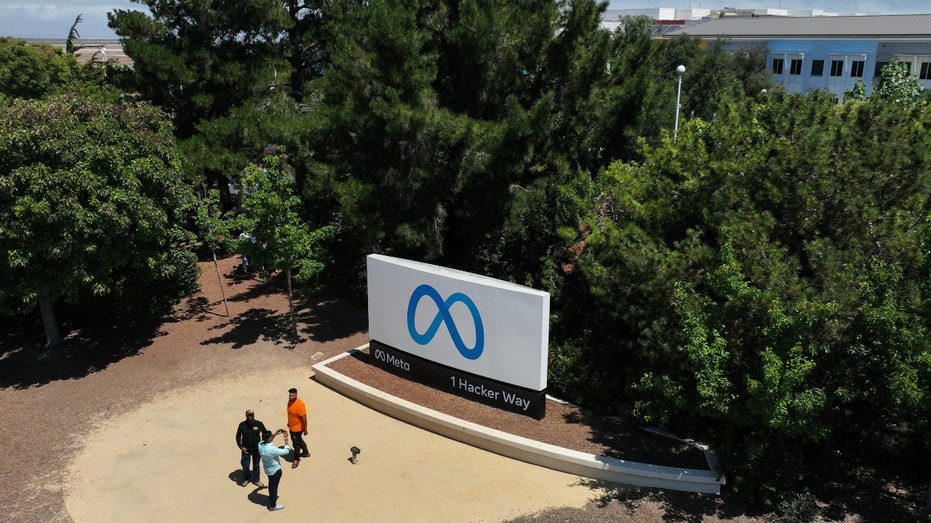 People in front of Meta HQ sign seen from air
