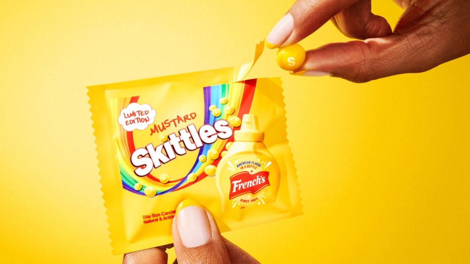 A woman opens a bag of mustard Skittles