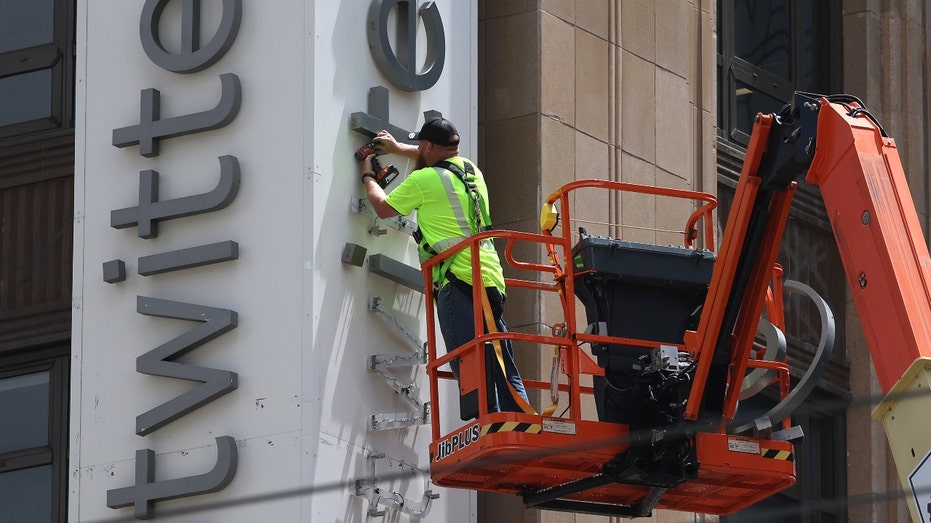A worker removes letters from the Twitter sign