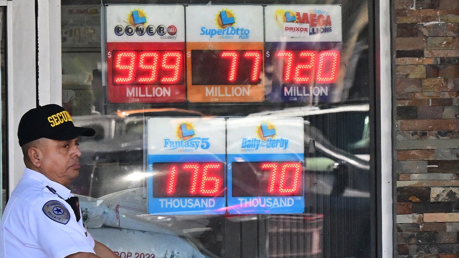 A security guard walks past signs displaying how much money could be won in the lottery, in Rosemead, California, on July 19, 2023.  (FREDERIC J. BROWN/AFP via Getty Images / Getty Images)