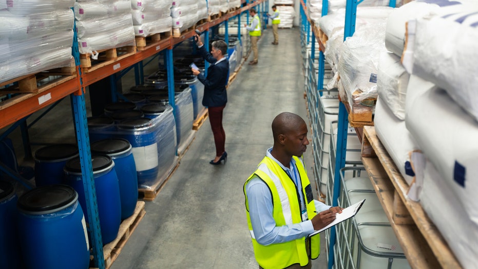 A Black worker and White worker in a warehouse