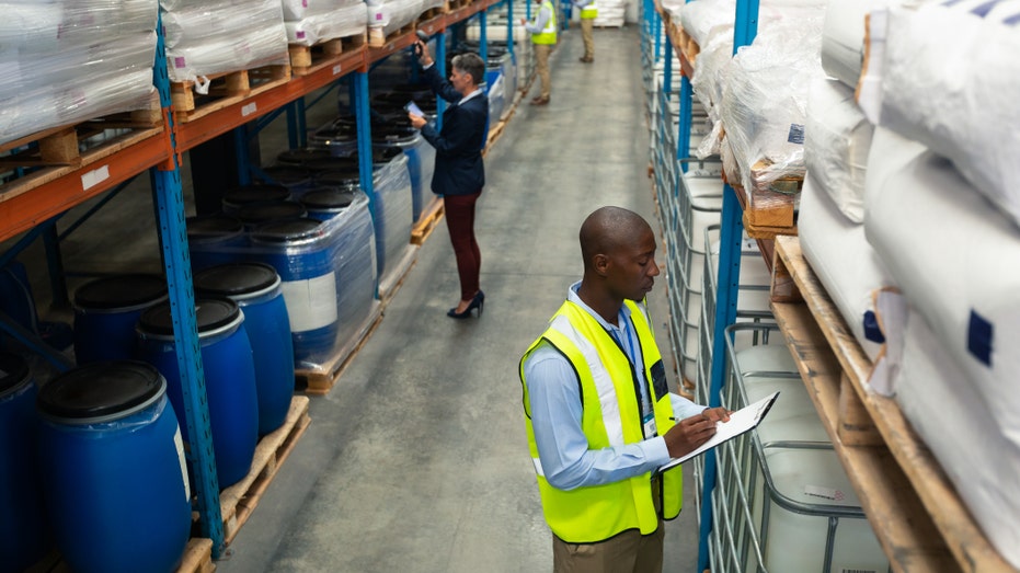 A Black worker and White worker in a warehouse