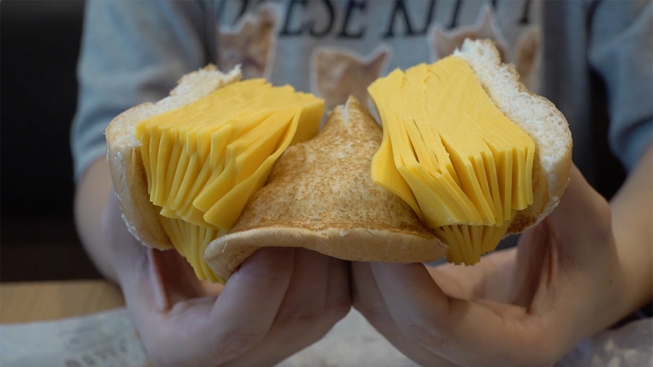 A customer holds Burger King Thailand's "Real Cheeseburger" 