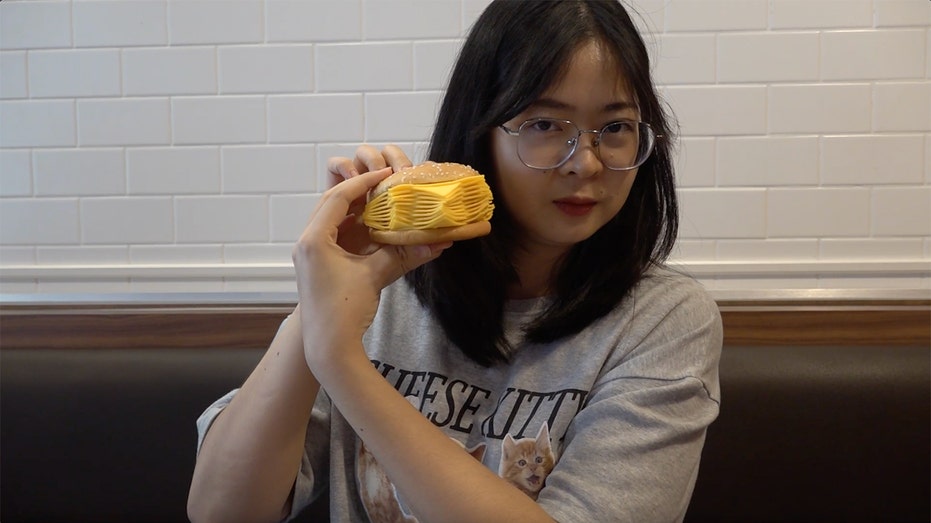 A customer holds up Burger King's 'real cheeseburger