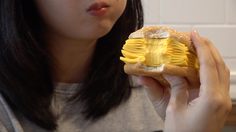 A customer bites into Burger King's all-cheese cheeseburger