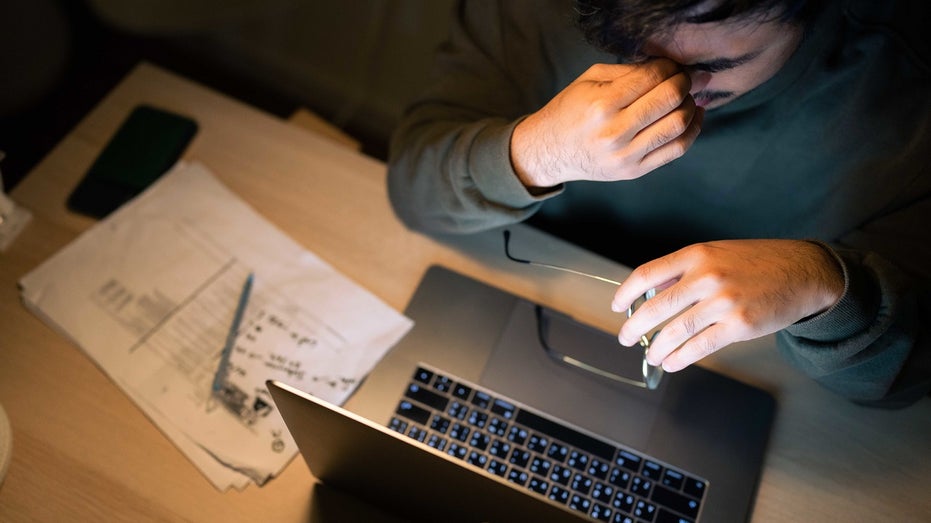 man stressed while going over bills