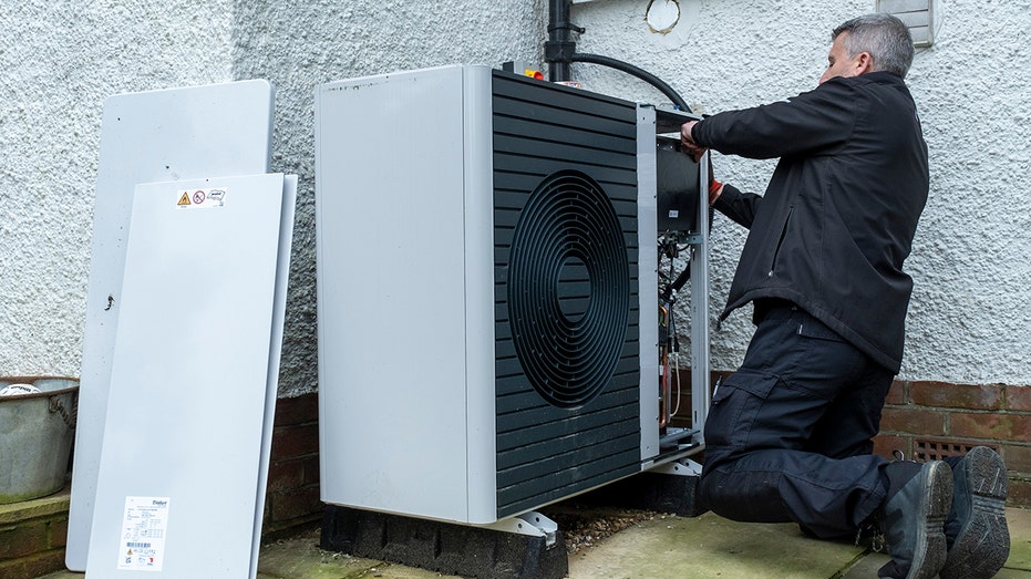 A heat pump repair man installs a heat pump