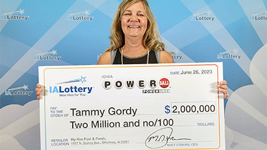 Tammy Gordy holding Iowa Lottery check