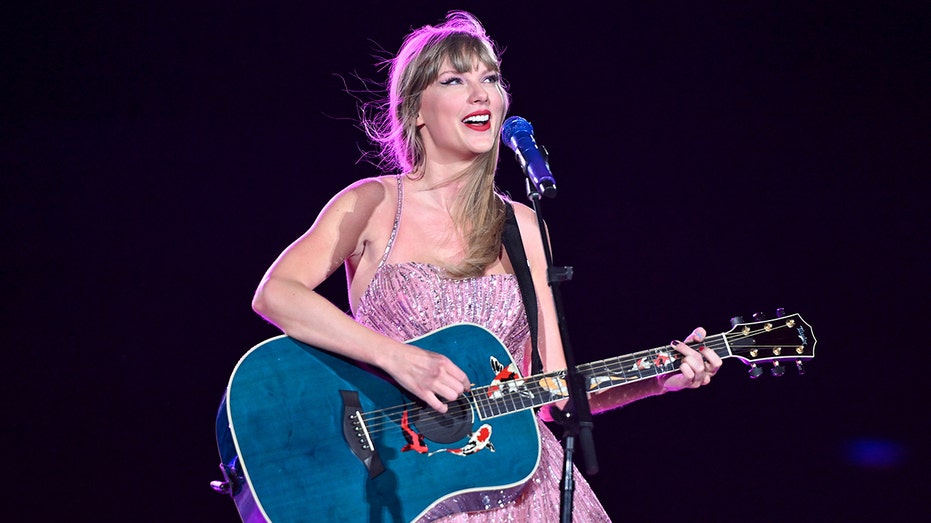 Taylor Swift strums blue guitar during stop on her Eras Tour