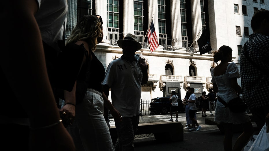 People walk past the New York Stock Exchange in New York City