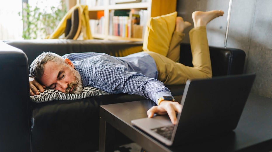 man sleeping pinch manus connected laptop keyboard astatine home