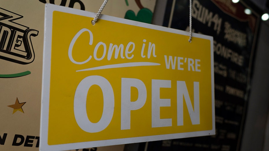 A yellow "come in we're open" sign