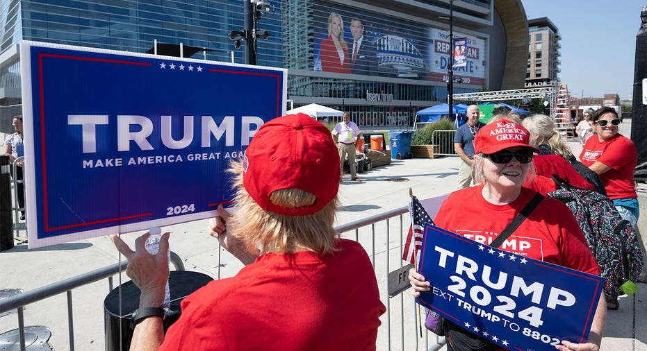 Trump supporters at debate with "Trump 2024" signs