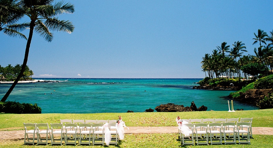 A wedding ceremony set up with chairs next to a view of a tropical lagoon in Maui.
