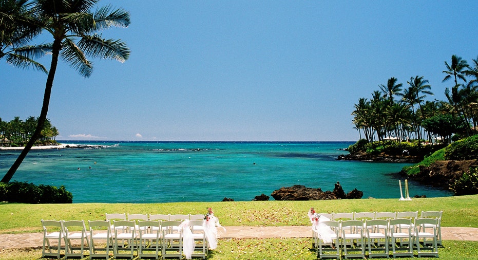 A wedding ceremony set up with chairs next to a view of a tropical lagoon in Maui.