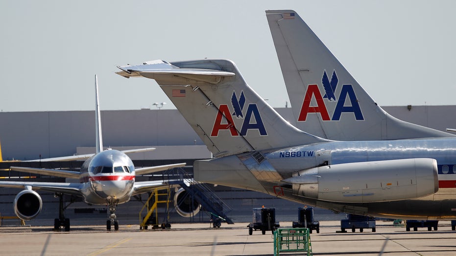 Gli aerei dell'American Airlines siedono vicino all'hangar dell'aeroporto internazionale di Dallas/Fort Worth, in Texas