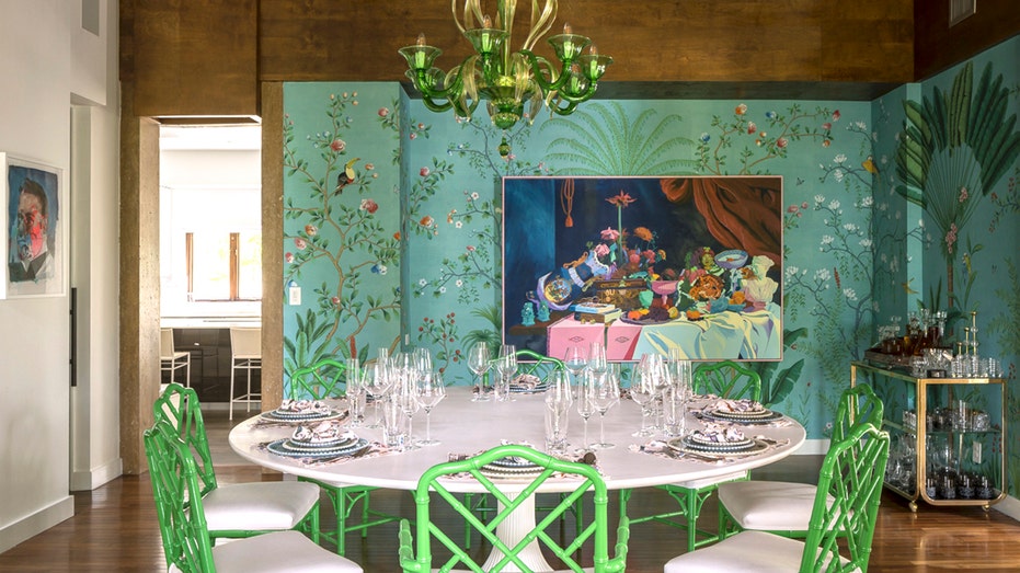 formal dining room with floral wallpaper and green chandalier