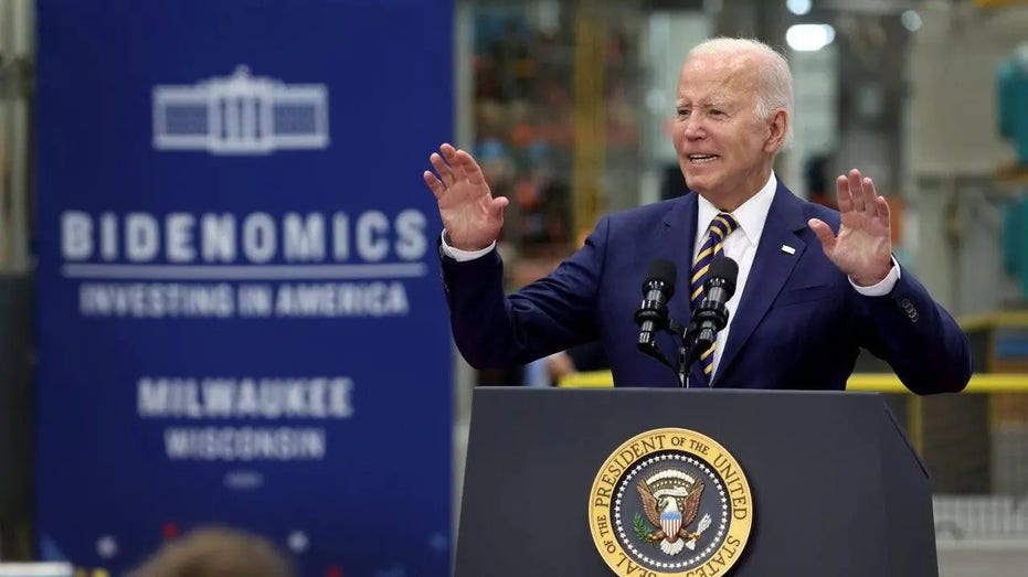 Joe Biden speaks in Wisconsin about Bidenomics behind podium