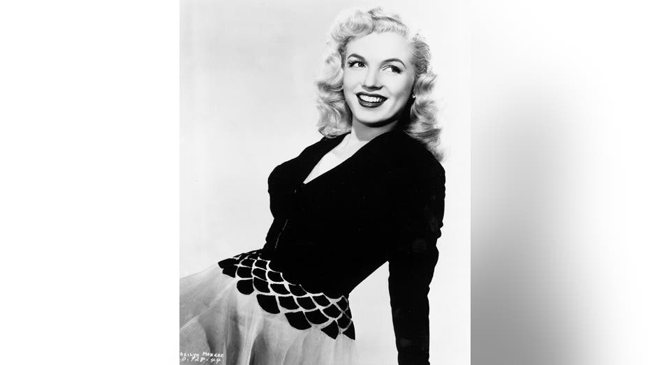 Marilyn Monroe wearing a black long sleeved sweater and a multiprinted skirt