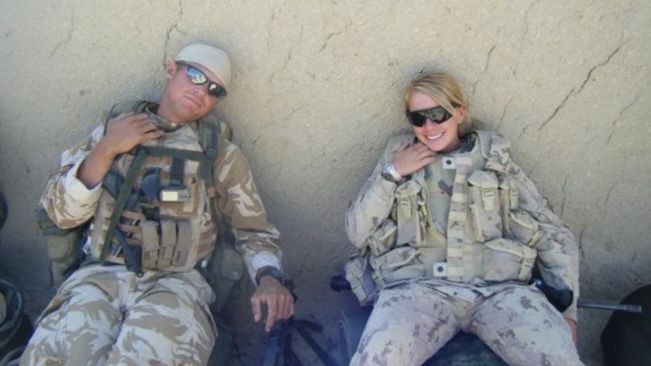 Kelsi Sheren smiling in her military gear next to a man wearing sunglasses