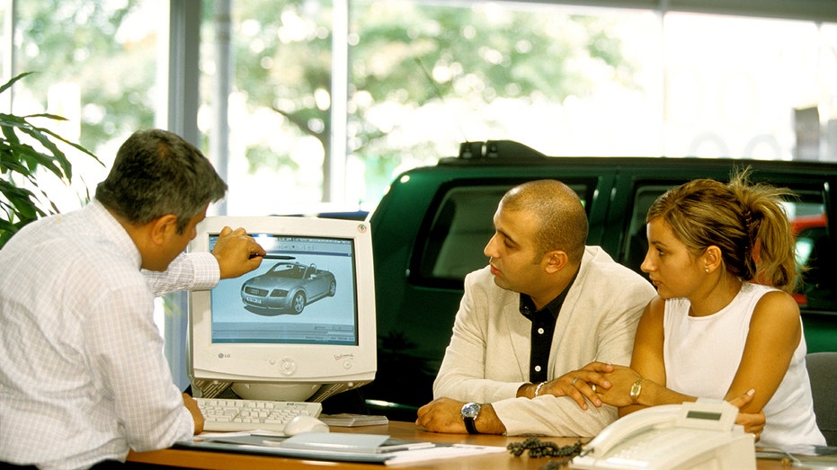 A couple talking to a car dealer