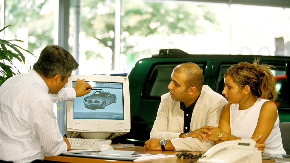 A couple talking to a car dealer