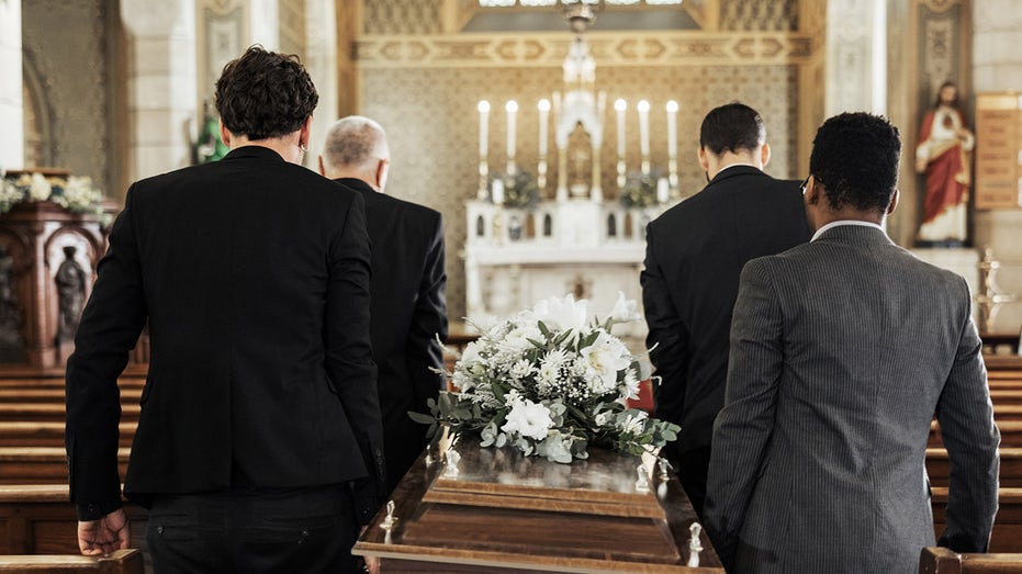 pallbearers carrying casket at a funeral