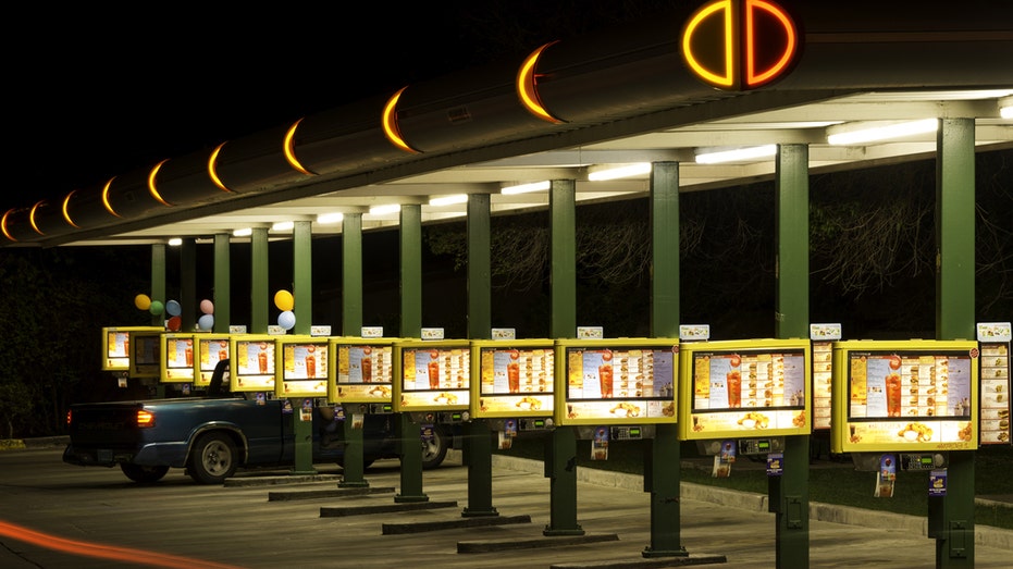 Sonic Drive-In booths, menus and neon lights set up at Albuquerque, New Mexico, location. A pickup truck is parked to order.