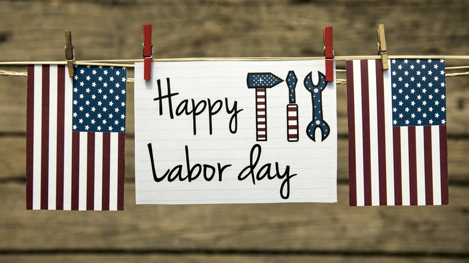 Labor Day sign hung up on string along with American flags and tool cutouts,