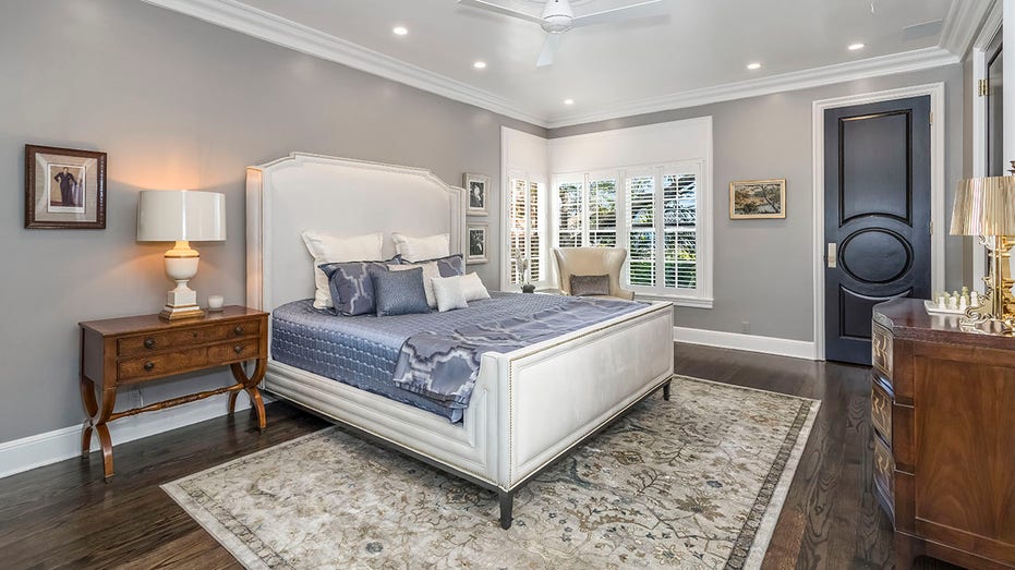 Bed with blue sheets and white bed frame in picture from LIberace's home