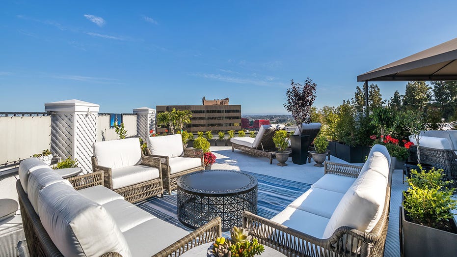 Seating space on Liberace's rooftop terrace with two couches and two chairs (matching) around a table