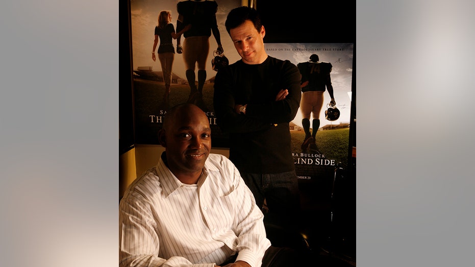 Broderick Johnson and Andrew Kosove pose together in front of posters for "The Blind Side"