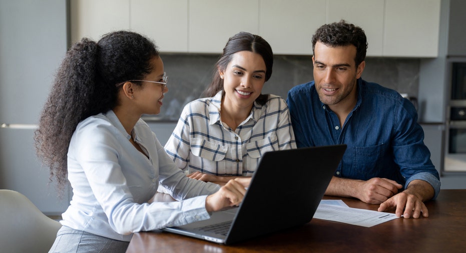 A financial advisor speaks with a woman and man.