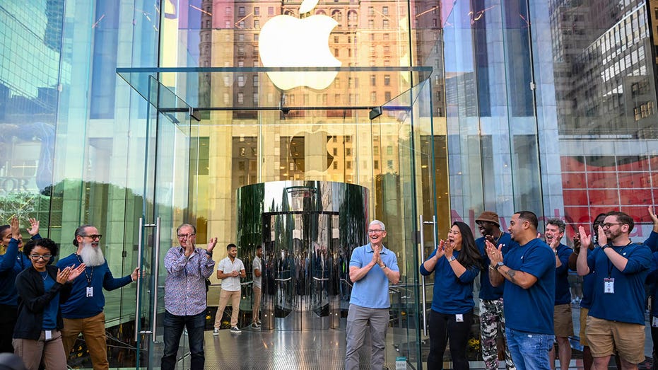 Tim Cook, Apple CEO, outside an Apple store with other Apple staff
