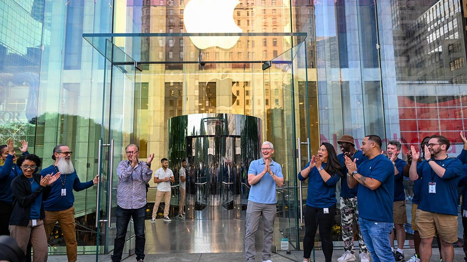 Tim Cook, Apple CEO, outside an Apple store with other Apple staff