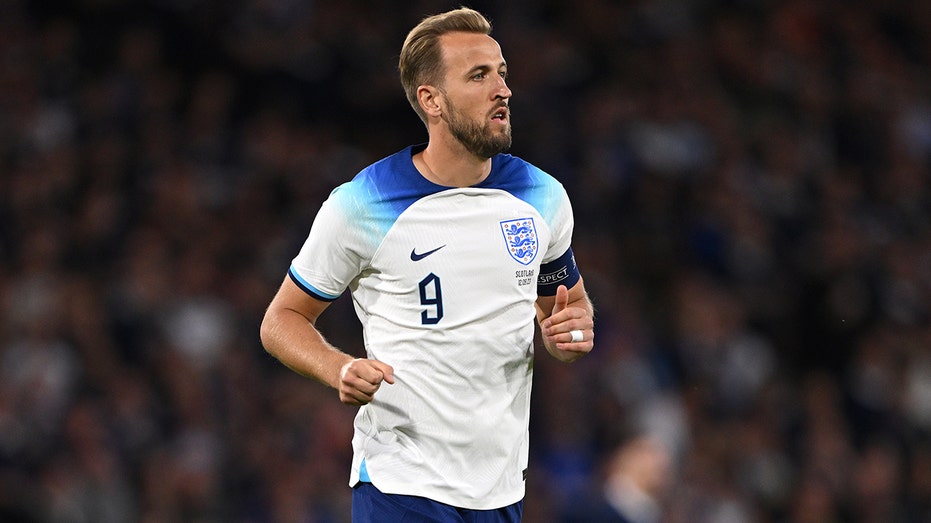 Harry Kane runs on soccer pitch