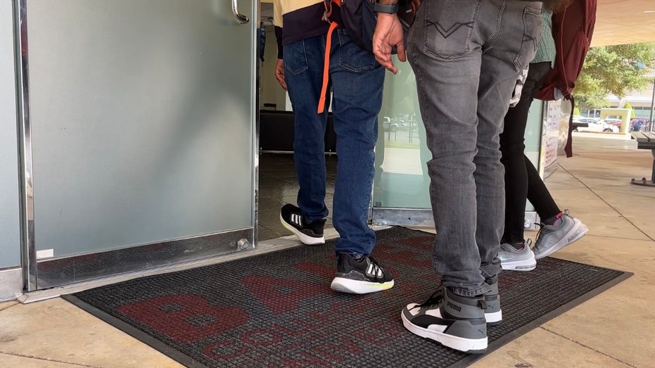 College students walking into a classroom.