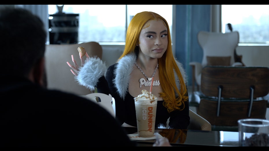 Ice Spice sits and talks with Ben Affleck in Dunkin's Ice Spice MUNCHKINS Drink commercial.