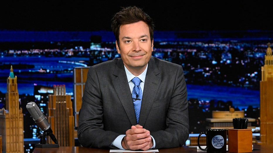 Jimmy Fallon sitting behind Tonight Show desk