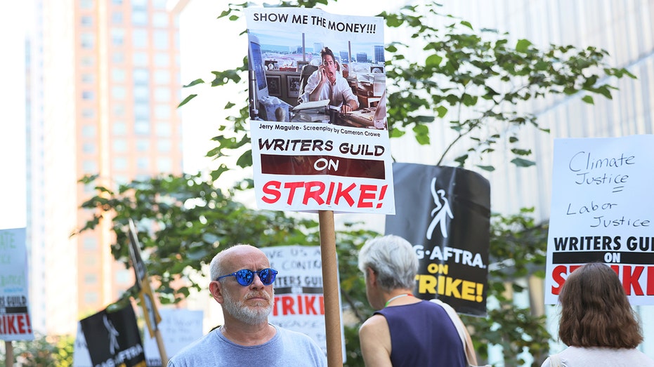 Striking WGA member carrying a picket sign