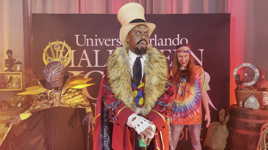 Universal's Halloween Horror Nights mascot Dr. Oddfellow stands with two other scare actors.