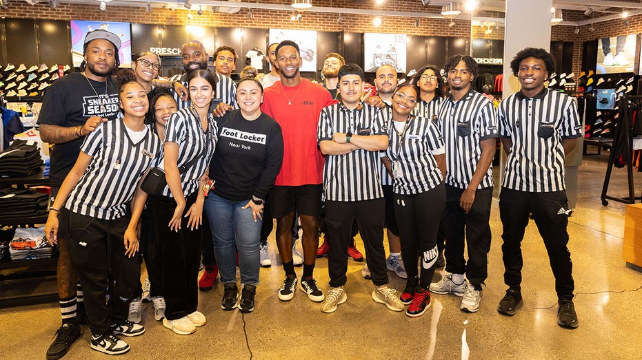 Victor Cruz poses with Foot Locker employees