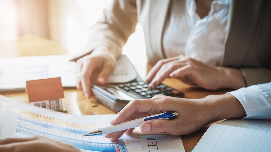 A person crunches numbers with a client.