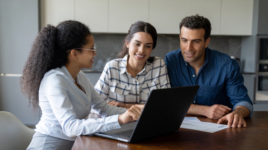 A financial advisor speaks with a woman and man.