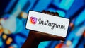 The Instagram logo is displayed on a smartphone screen.