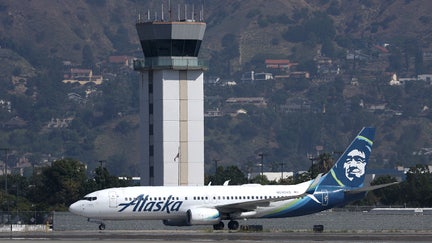 BURBANK, CALIFORNIA - SEPTEMBER 25: The control tower at Hollywood Burbank Airport stands over an Alaska Airlines plane as it taxis on September 25, 2023 in Burbank, California. Transportation Secretary Pete Buttigieg is warning that vital training for new air traffic controllers would be paused if the government shuts down later this week. The Department of Transportation currently has 2,600 much needed air traffic controllers undergoing training and employs 1,200 fewer certified controllers than that agency did 10 years ago. 