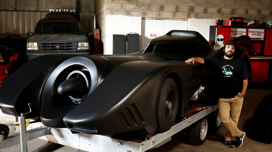 Franck Galiegue stands in front of Batmobile.