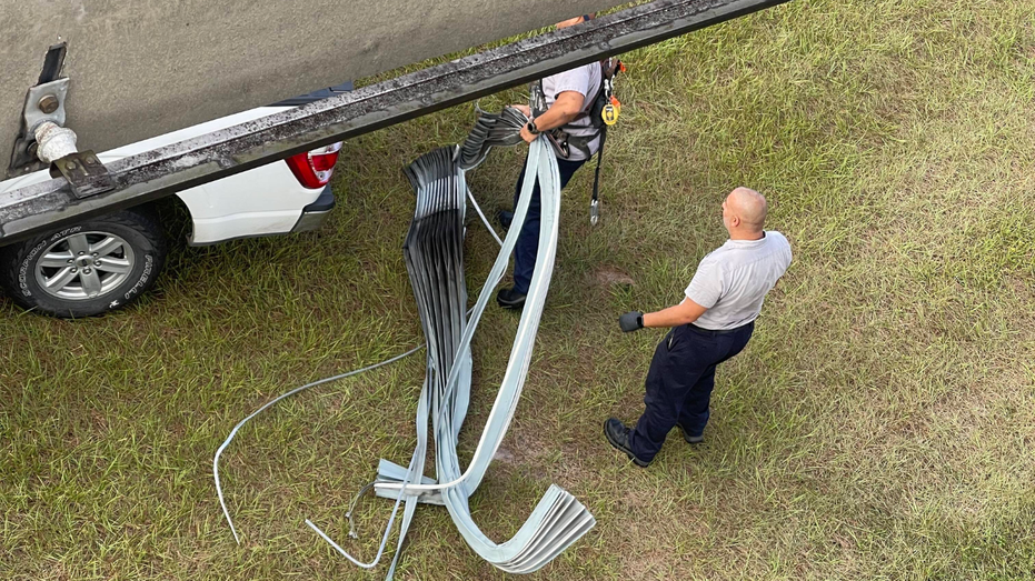 View from Disney World monorail of rescue workers taking off part of the tire