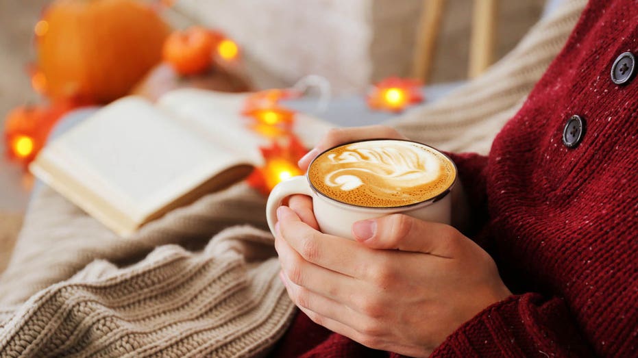 Person sitting with coffee in fall setting